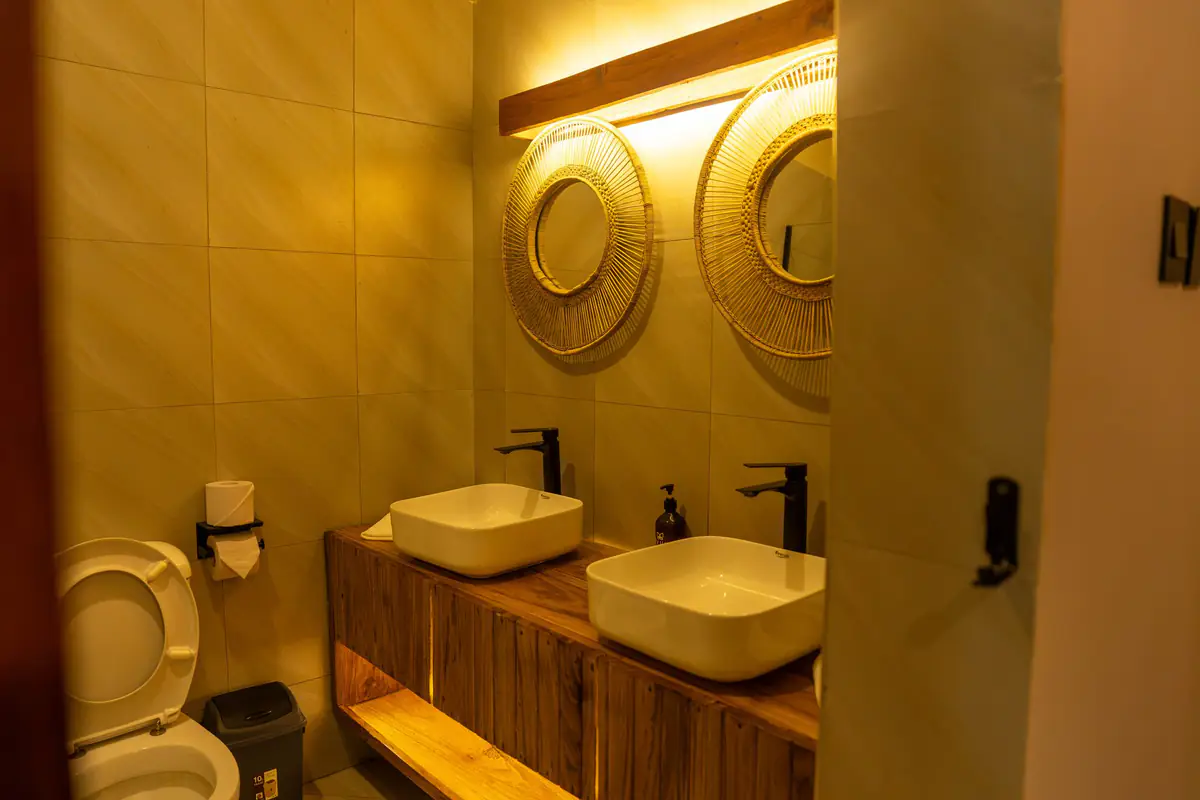 Bathroom with twin basins and woven mirrors at Mvuli Farm Lodge