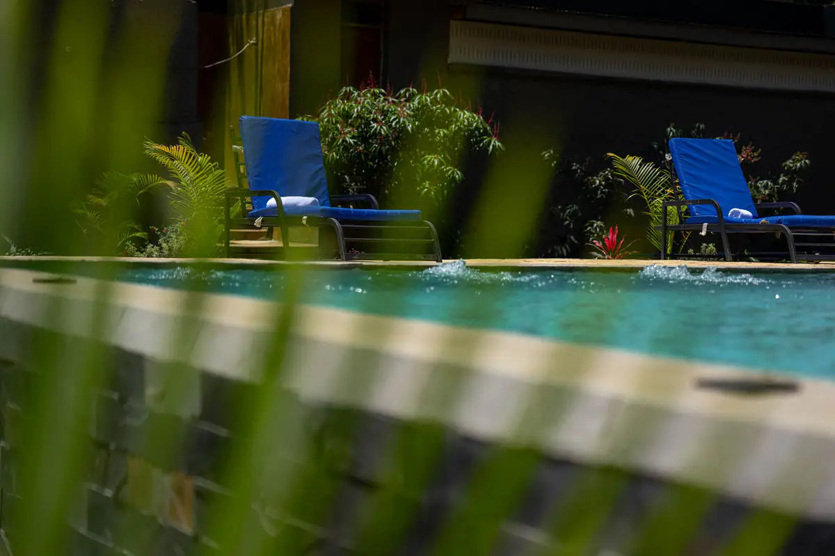 Blue loungers beside the pool at Mvuli Farm Lodge