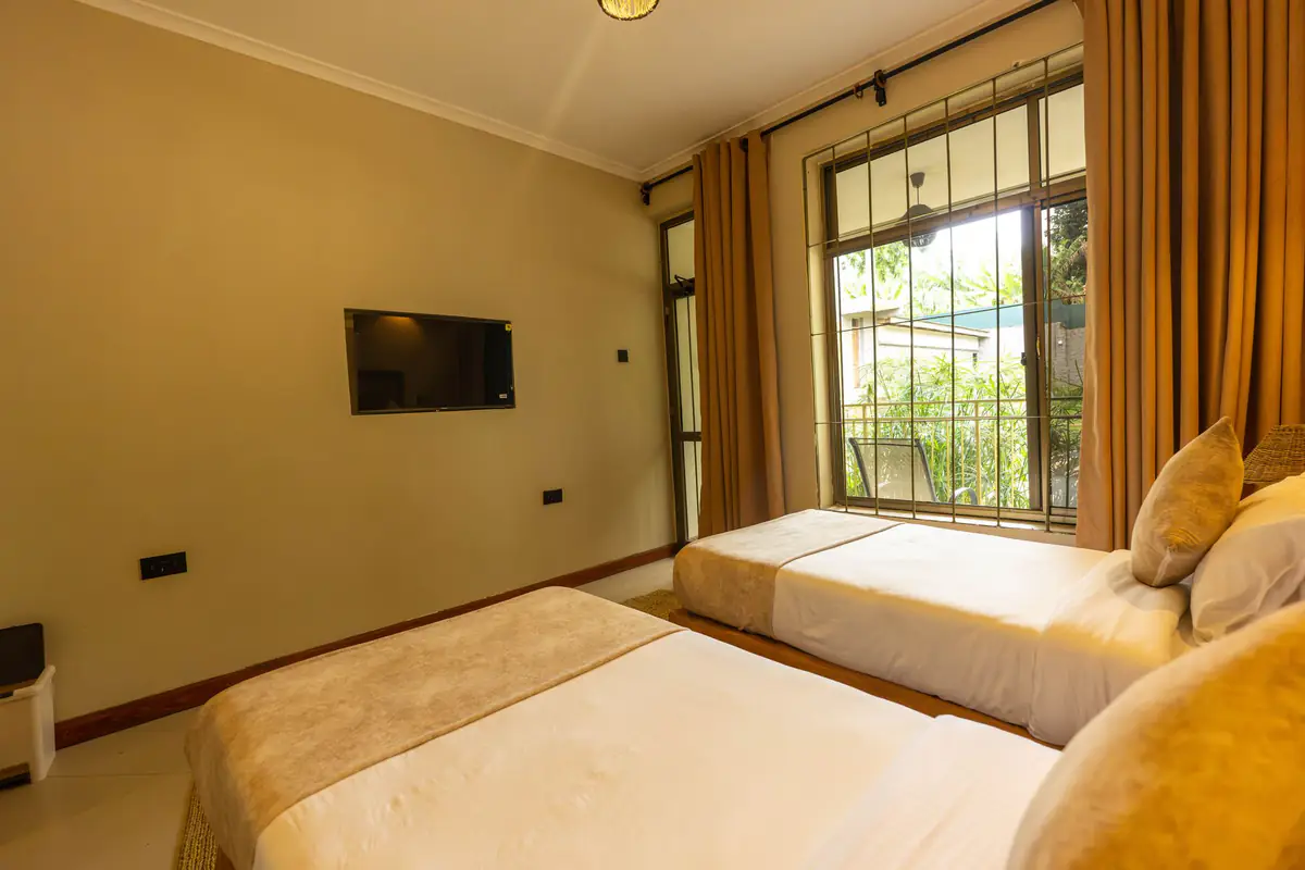 Twin beds by the window at Mvuli Farm Lodge